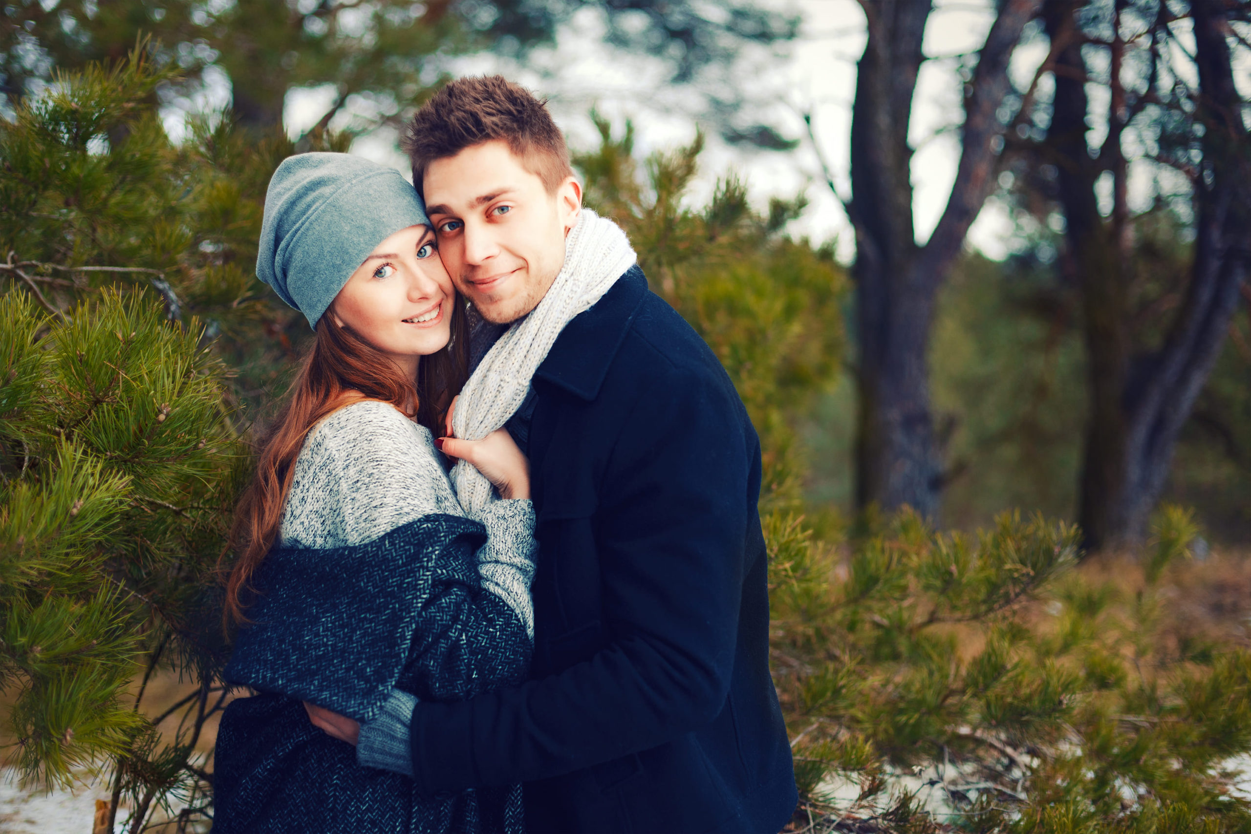 happy-couple-warm-hat-scarf-hugging-outdoor-winter